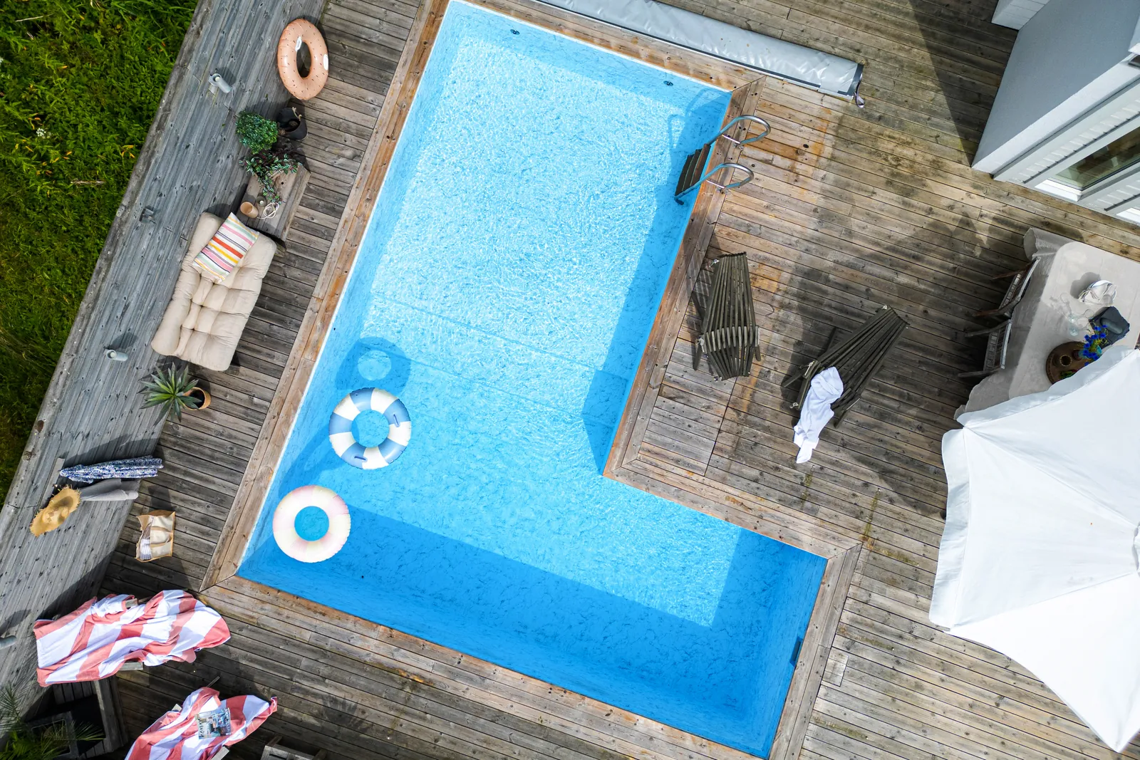 När behövs spridningstillstånd för drönarbilder? 1 Pool med trädäck och solstolar, fotograferad rakt ovanifrån med drönare