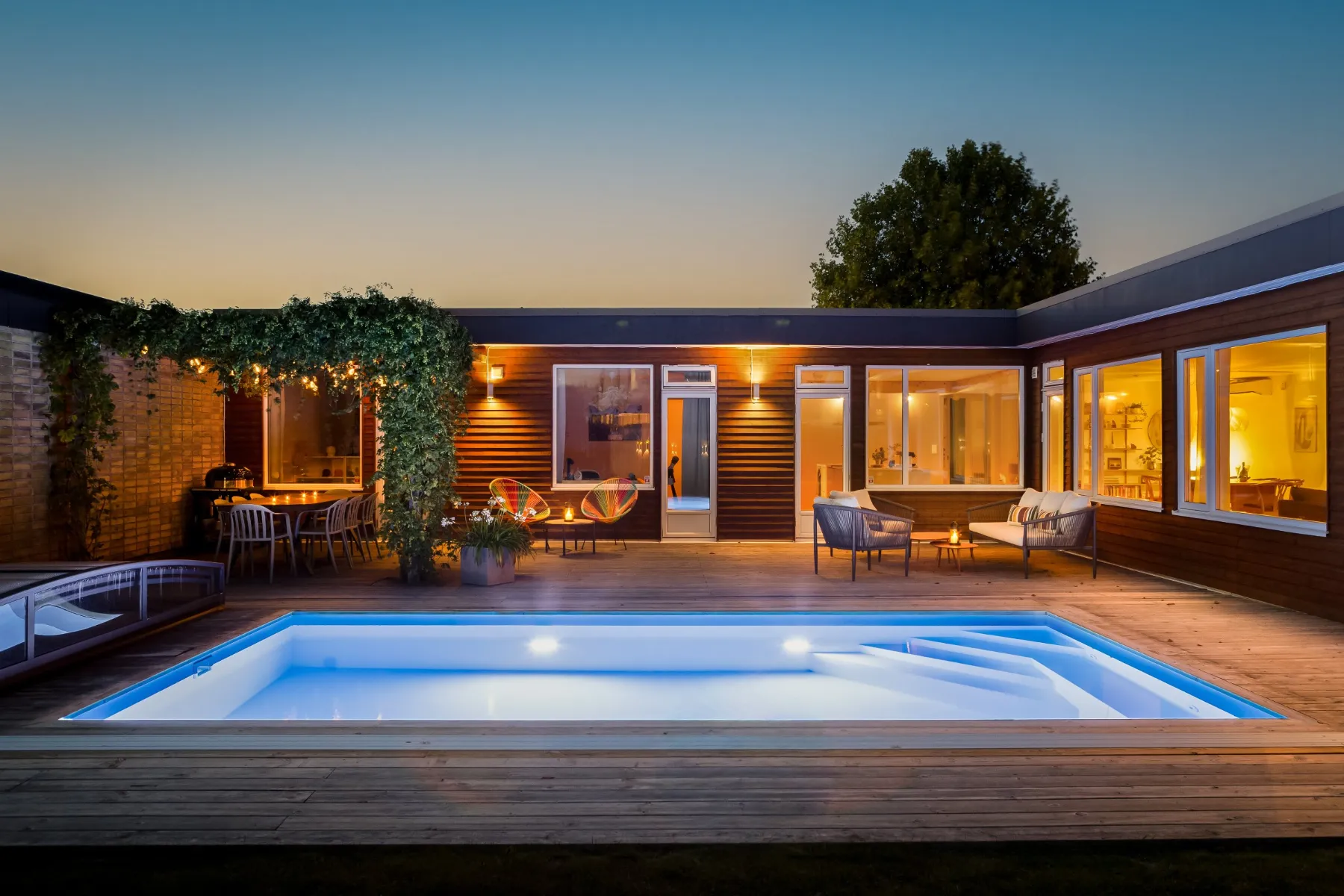 Snyggast i höst 24 Innergård med upplyst pool och tända fönster en kväll