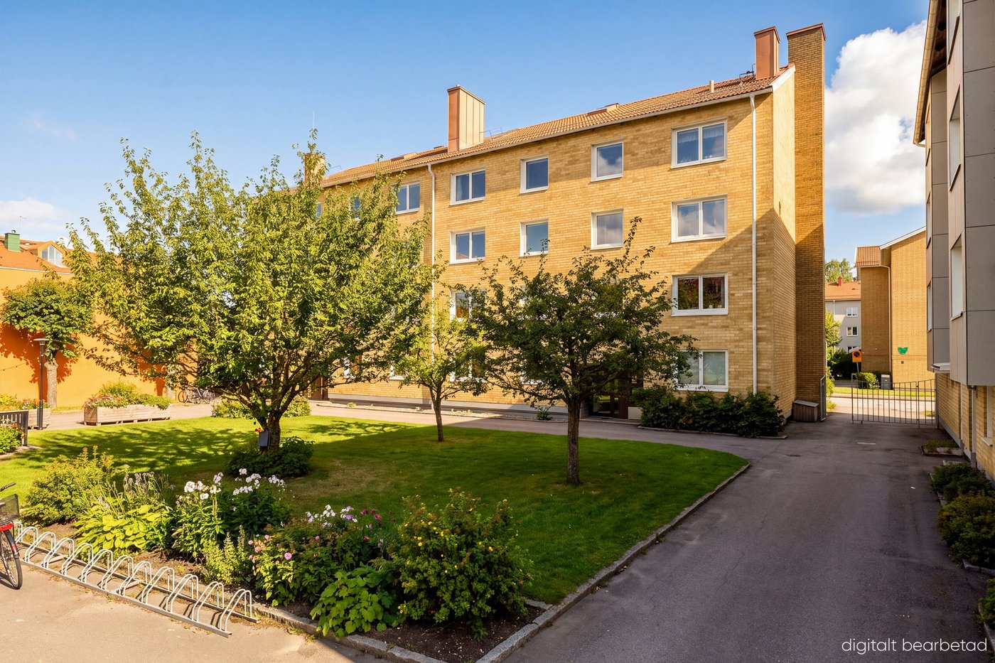 Vad är e-styling? 5 Flerbostadshus i gult tegel med grönt gräs och blå himmel